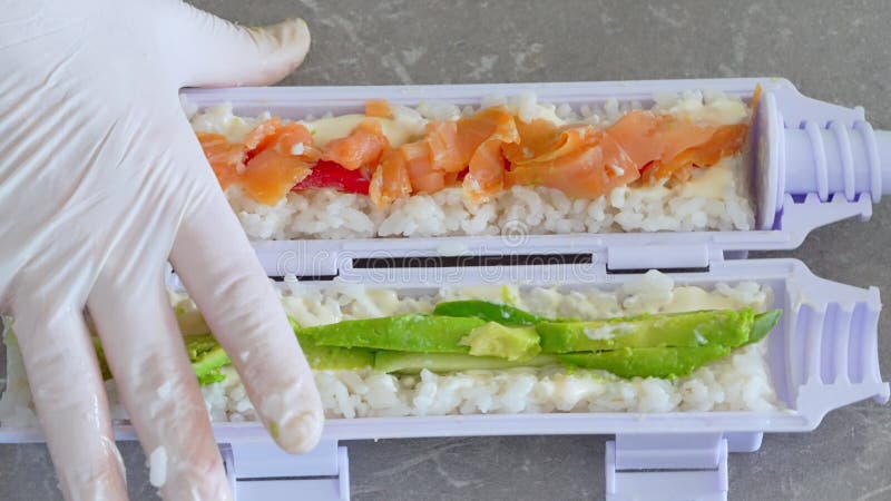 El hombre hábilmente prepara sushi a mano dando forma al arroz en picaduras perfectas.