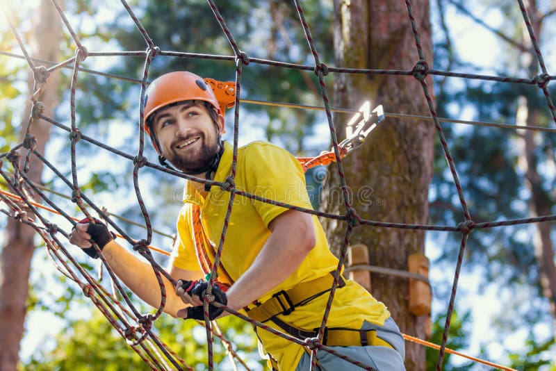 El hombre joven disfruta de ocio activo en parque extremo de la cuerda imágenes de archivo libres de regalías El hombre joven disfruta de ocio activo en parque extremo de la cuerda imágenes de archivo libres de regalías