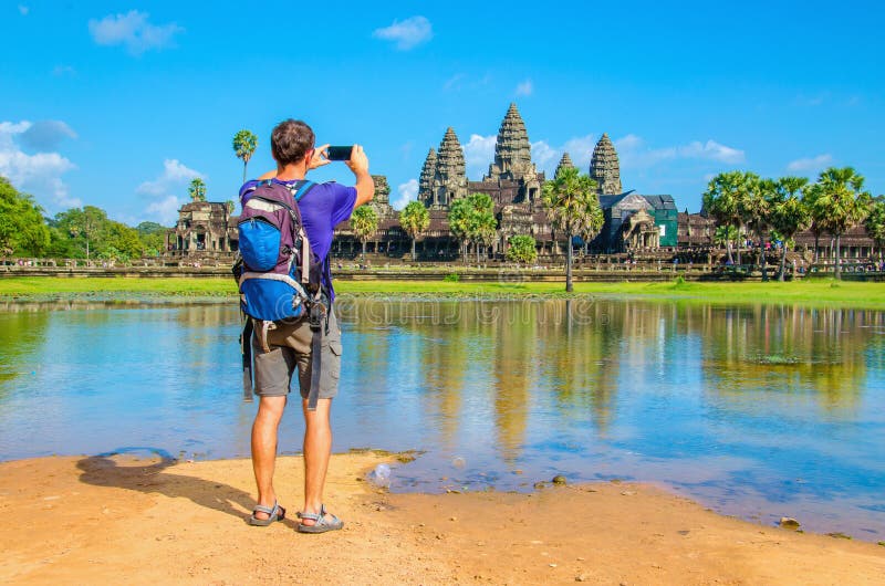 El hombre joven está tomando una foto del templo de Angkor Wat foto de archivo El hombre joven está tomando una foto del templo de Angkor Wat foto de archivo
