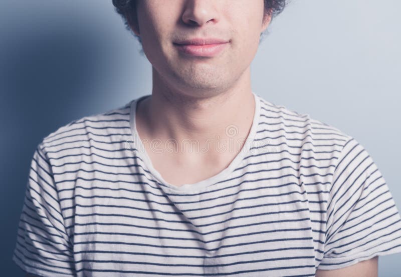El hombre joven feliz es camiseta del stripey fotografía de archivo El hombre joven feliz es camiseta del stripey fotografía de archivo