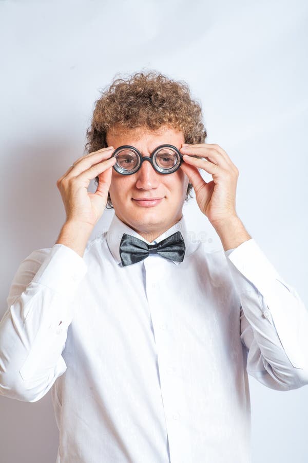 El hombre joven hermoso en estudio de los vidrios del empollón tiró encendido foto de archivo El hombre joven hermoso en estudio de los vidrios del empollón tiró encendido foto de archivo