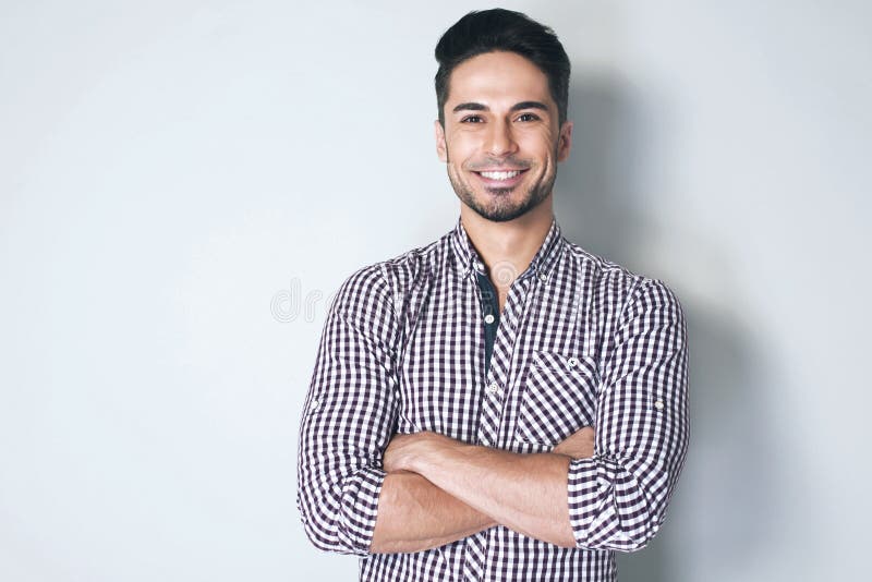 El hombre joven hermoso es sonriente y de mirada de la cámara imagen de archivo El hombre joven hermoso es sonriente y de mirada de la cámara imagen de archivo