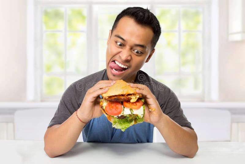 El hombre joven tiene un gran deseo de comer una hamburguesa
