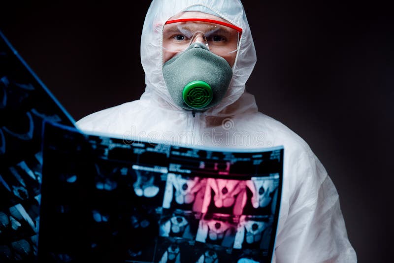 Medic man in white hazmat protective respirator glasses hold examines effects on human lungs and reproductive organs pneumonia epidemic coronavirus. Medic man in white hazmat protective respirator glasses hold examines effects on human lungs and reproductive organs pneumonia epidemic coronavirus.