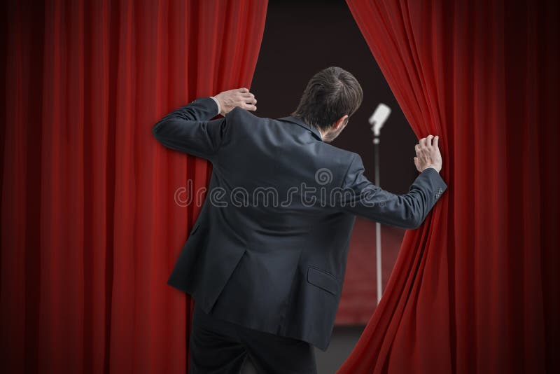 El hombre nervioso tiene miedo de discurso público y está ocultando detrás de la cortina