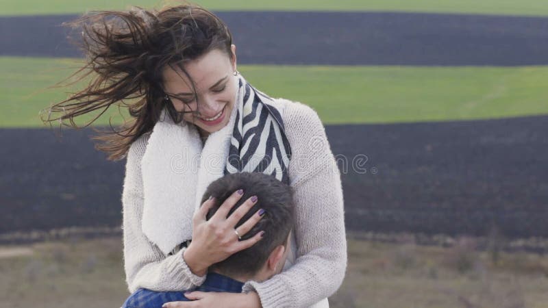 El hombre precioso tuerce a su muchacha bonita en las manos en la naturaleza lentamente