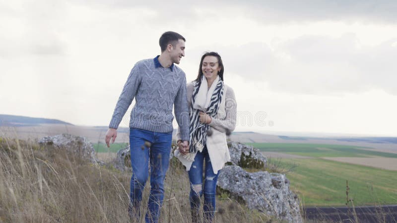 El hombre precioso viene a su mujer, la abraza y besa en la naturaleza 4K