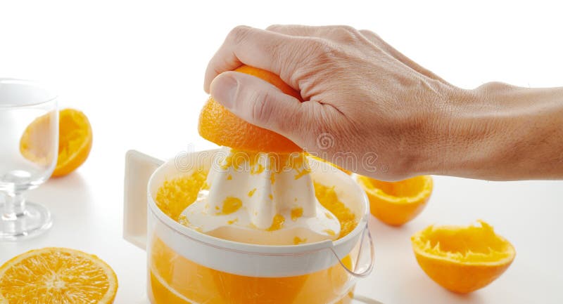 El hombre prepara un zumo de naranja recién exprimido fotografía de archivo