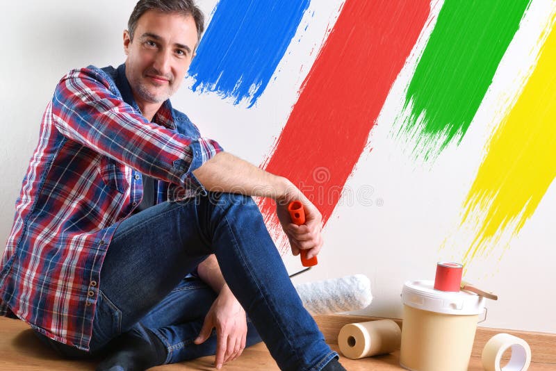 El hombre que se sentaba en el entarimado y la pared pintó con el detalle de los colores fotos de archivo El hombre que se sentaba en el entarimado y la pared pintó con el detalle de los colores fotos de archivo