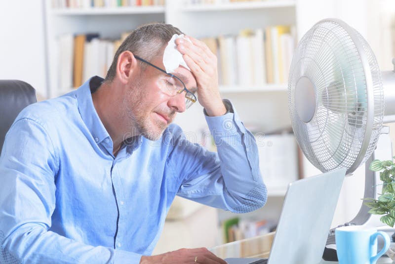 El hombre sufre de calor en la oficina o en casa