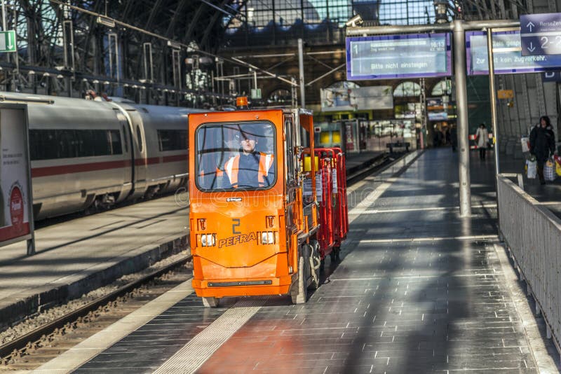 El hombre transporta mercancías en un coche eléctrico en el ferrocarril fotografía de archivo El hombre transporta mercancías en un coche eléctrico en el ferrocarril fotografía de archivo