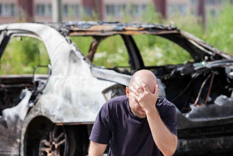 El hombre trastornado gritador en el fuego del incendio provocado quemó los desperdicios del vehículo del coche fotos de archivo libres de regalías El hombre trastornado gritador en el fuego del incendio provocado quemó los desperdicios del vehículo del coche fotos de archivo libres de regalías