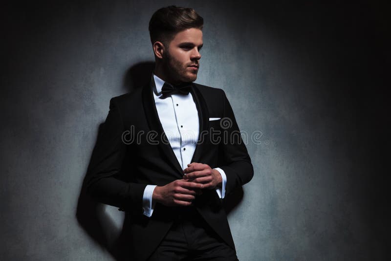 El hombre unshaved hermoso que lleva el smoking negro mira para echar a un lado fotos de archivo