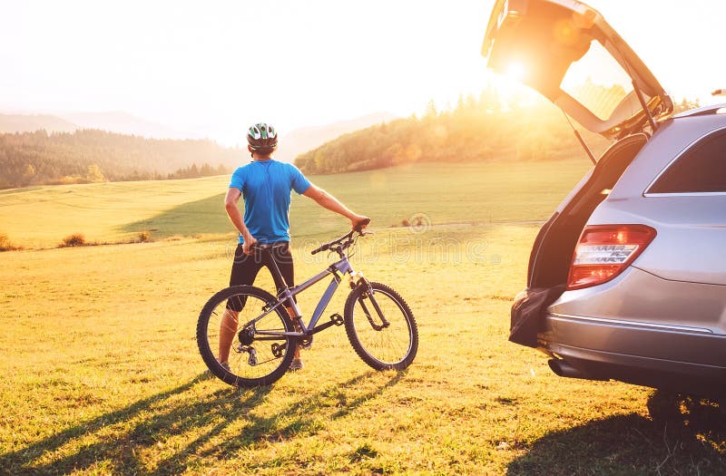 El hombre vino en auto en montañas con su bicicleta en el tejado Concepto biking de la monta?a fotografía de archivo El hombre vino en auto en montañas con su bicicleta en el tejado Concepto biking de la monta?a fotografía de archivo
