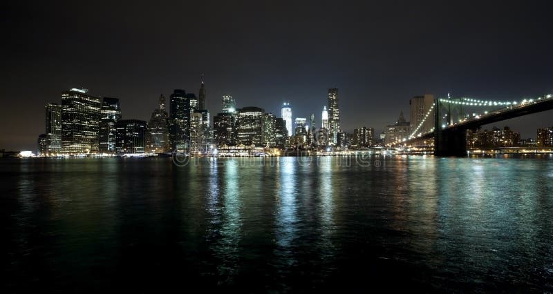 The New York City skyline at night w Brooklyn Bridge and Freedom tower. The New York City skyline at night w Brooklyn Bridge and Freedom tower
