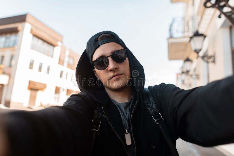 El Inconformista Urbano Elegante Del Hombre Joven En Gafas De Sol Del  Vintage En Una Sudadera Con Capucha De Moda En Una Gorra De Imagen de  archivo - Imagen de retrato, resorte