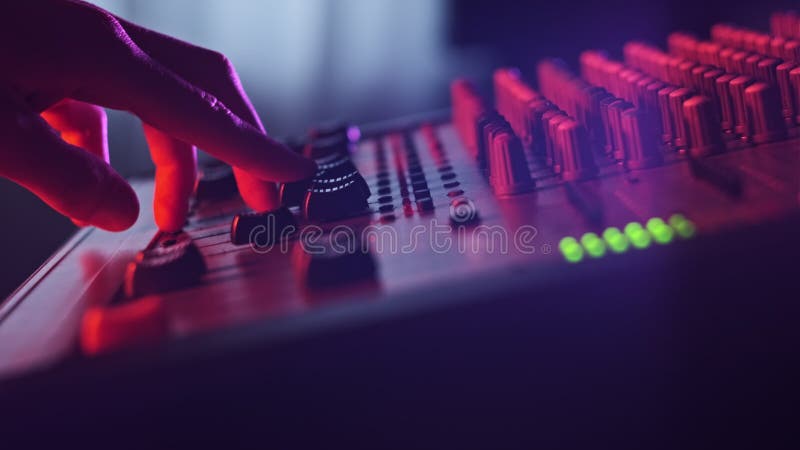 El ingeniero de sonido se desplaza hacia arriba y hacia abajo en el mezclador de audio en el cierre de la luz de neón metrajes