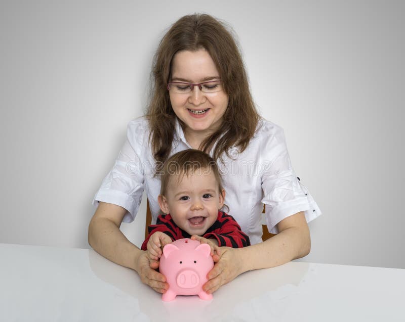 El ingenio de madre joven su niño está recogiendo monedas en vagos guarros del dinero foto de archivo El ingenio de madre joven su niño está recogiendo monedas en vagos guarros del dinero foto de archivo