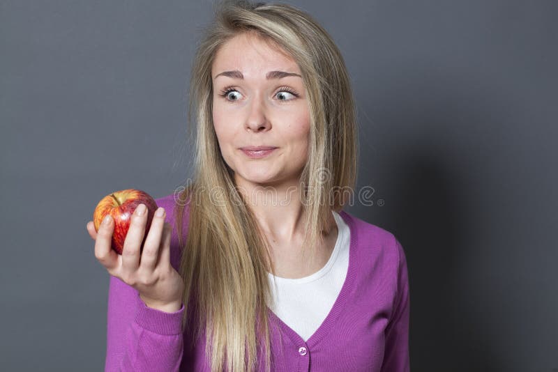 El Innocent cautivaba a la muchacha 20s que sostenía la manzana apetitosa con envidia imagen de archivo libre de regalías El Innocent cautivaba a la muchacha 20s que sostenía la manzana apetitosa con envidia imagen de archivo libre de regalías