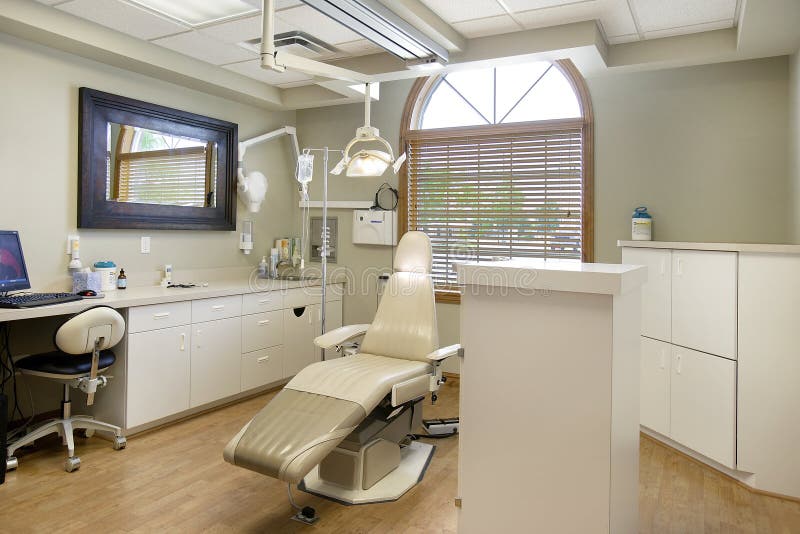 The bright comfortable interior of the operatory in a dentists office with modern patient chair , lighting, and other equipment. The bright comfortable interior of the operatory in a dentists office with modern patient chair , lighting, and other equipment.