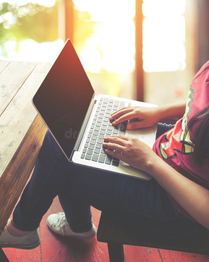 el ` joven hermoso s de la mujer del inconformista da el trabajo ocupado en su ordenador portátil que se sienta en la tabla de ma fotografía de archivo libre de regalías el ` joven hermoso s de la mujer del inconformista da el trabajo ocupado en su ordenador portátil que se sienta en la tabla de ma fotografía de archivo libre de regalías