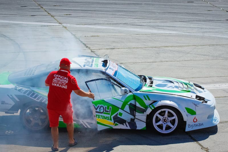 El juez oficial abre una puerta de un coche de la deriva de Nissan Silvia para ventilarlo dentro y para decir el resultado al con fotografía de archivo libre de regalías El juez oficial abre una puerta de un coche de la deriva de Nissan Silvia para ventilarlo dentro y para decir el resultado al con fotografía de archivo libre de regalías