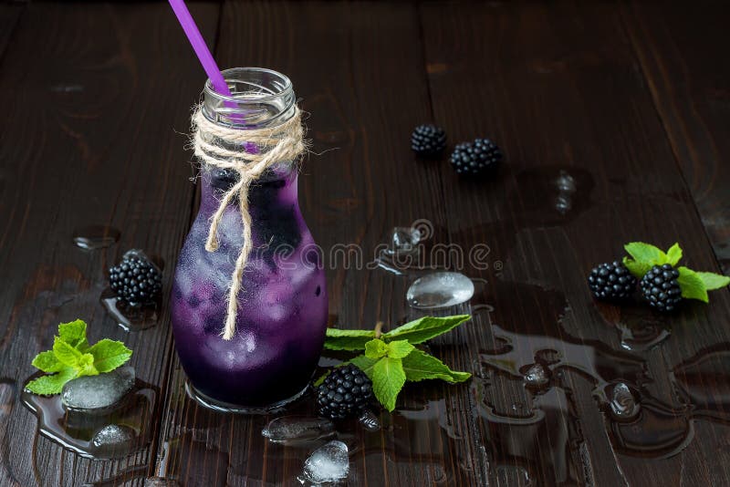 El jugo de restauración de la zarzamora en eco del vintage diseña la botella en la tabla de madera oscura rústica Bebida fría de foto de archivo libre de regalías El jugo de restauración de la zarzamora en eco del vintage diseña la botella en la tabla de madera oscura rústica Bebida fría de foto de archivo libre de regalías