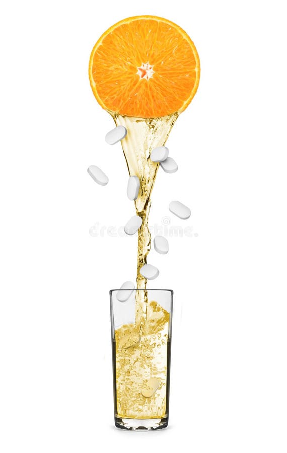 El jugo fluye de una naranja con las píldoras que caen en vidrio foto de archivo libre de regalías El jugo fluye de una naranja con las píldoras que caen en vidrio foto de archivo libre de regalías
