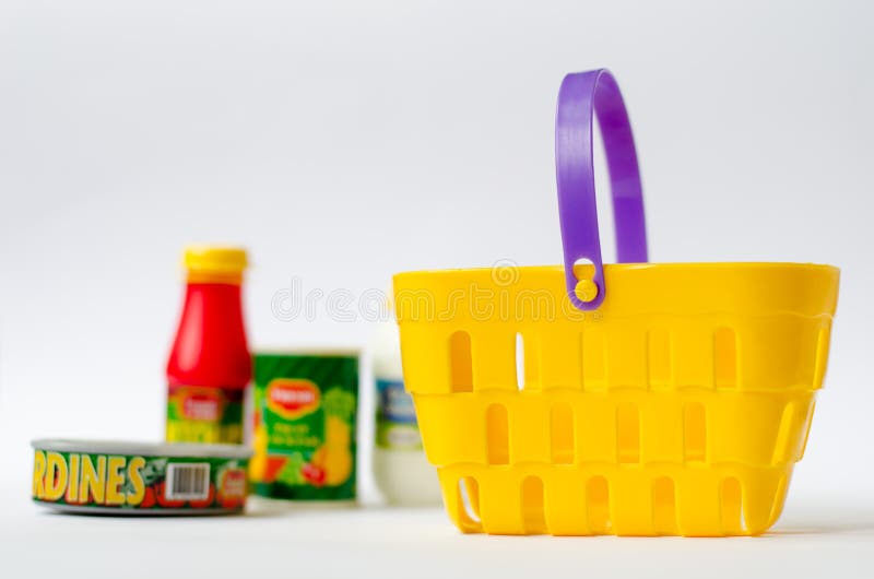 Colourful plastic toy a shopping basket is empty yellow on a background products. Colourful plastic toy a shopping basket is empty yellow on a background products