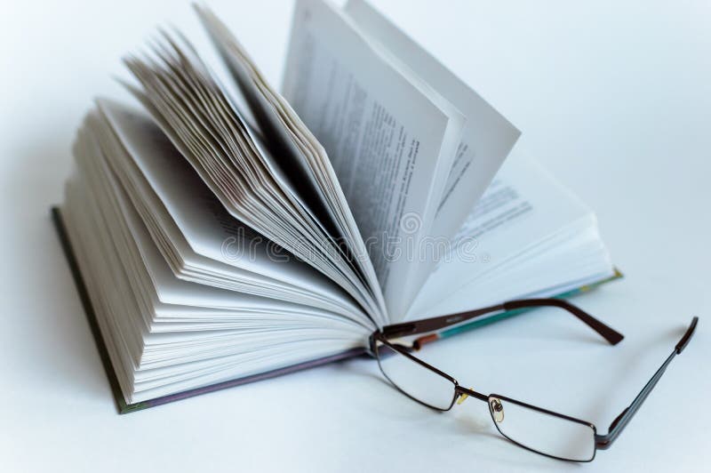 El libro abierto miente en un fondo blanco en el aislamiento en un fondo blanco Gafas fotografía de archivo libre de regalías El libro abierto miente en un fondo blanco en el aislamiento en un fondo blanco Gafas fotografía de archivo libre de regalías