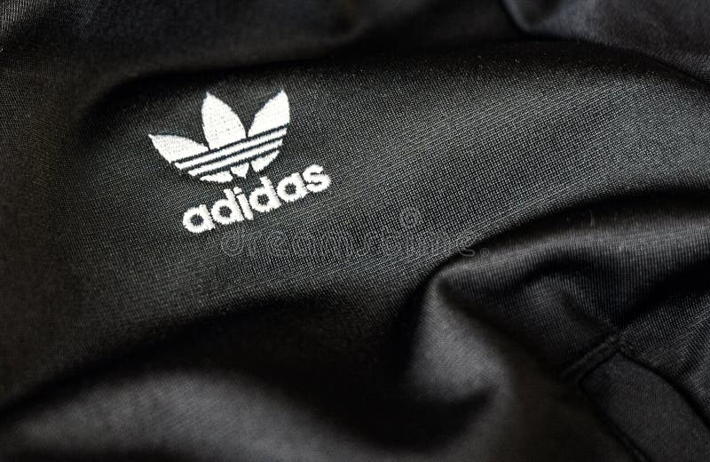 El Logotipo De Adidas Cosido En Una Tela De Poliéster Reciclado De Color  Negro. Ropa Deportiva Y Logotipo Icónico. Marca De Ropa D Imagen de archivo  editorial - Imagen de trébol, ilustrativo: