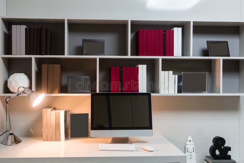 El lugar de trabajo hecho en casa, un ordenador se está colocando en una tabla, una lámpara de escritorio es brillante en el fond foto de archivo El lugar de trabajo hecho en casa, un ordenador se está colocando en una tabla, una lámpara de escritorio es brillante en el fond foto de archivo