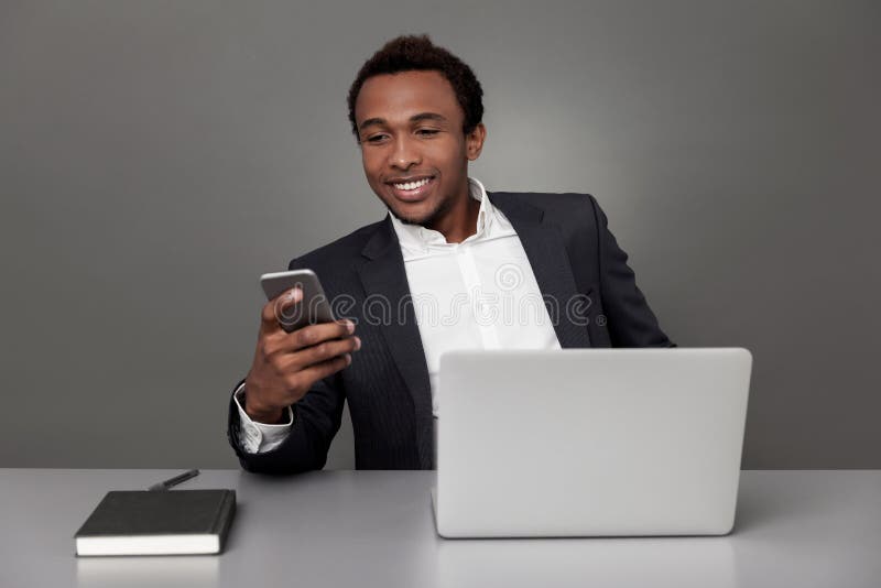 El mandar un SMS africano del hombre de negocios imagen de archivo El mandar un SMS africano del hombre de negocios imagen de archivo