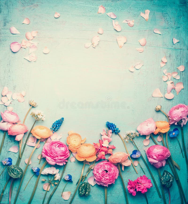 El marco floral con las flores y los pétalos preciosos, pastel retro entonó en fondo de la turquesa del vintage