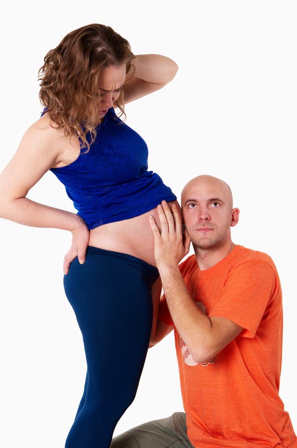 El marido oye por casualidad en el vientre de su esposa foto de archivo libre de regalías El marido oye por casualidad en el vientre de su esposa foto de archivo libre de regalías