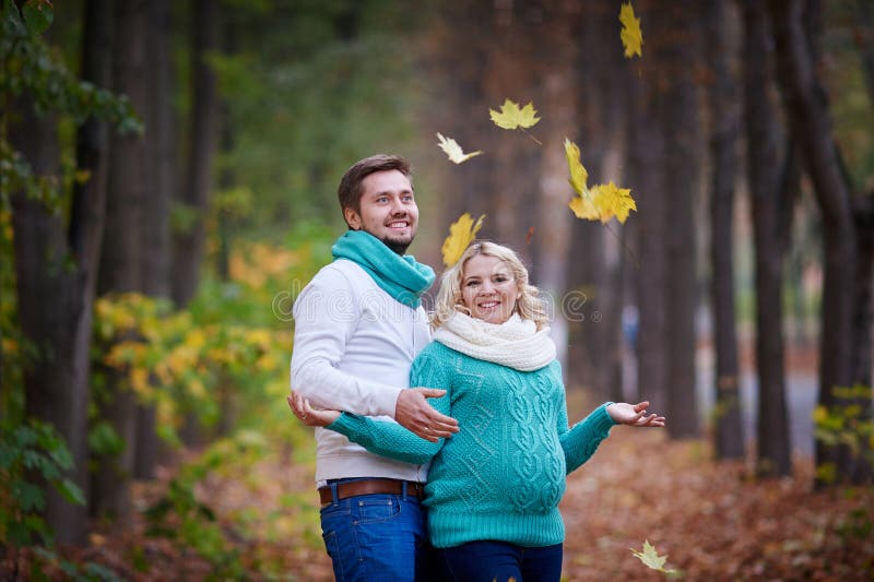 El marido y la esposa embarazada están caminando en parque del otoño fotografía de archivo libre de regalías El marido y la esposa embarazada están caminando en parque del otoño fotografía de archivo libre de regalías