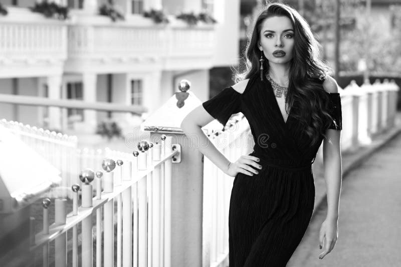 El modelo femenino magnífico en vestido negro con el recorte lleva a hombros fotos de archivo El modelo femenino magnífico en vestido negro con el recorte lleva a hombros fotos de archivo