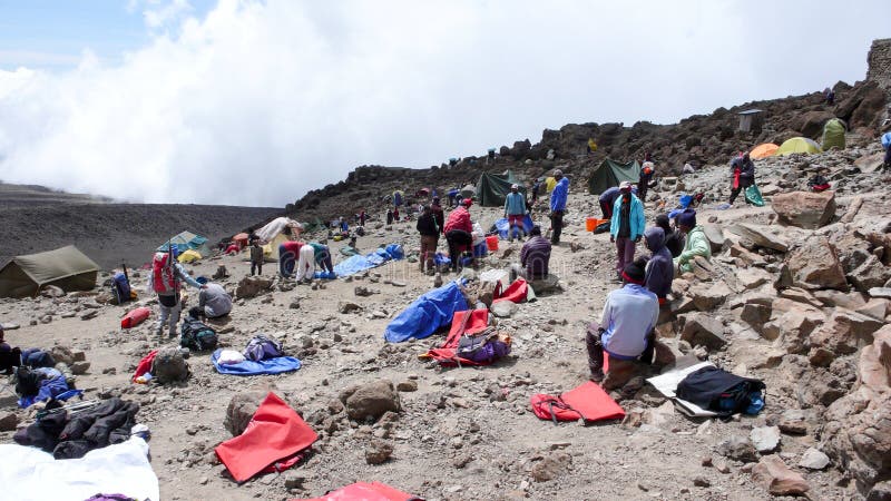 El monte Kilimanjaro/Tanzania: 7 de enero de 2016: alto campo en el monte Kilimanjaro con muchos porteros que embalan encima del fotos de archivo El monte Kilimanjaro/Tanzania: 7 de enero de 2016: alto campo en el monte Kilimanjaro con muchos porteros que embalan encima del fotos de archivo