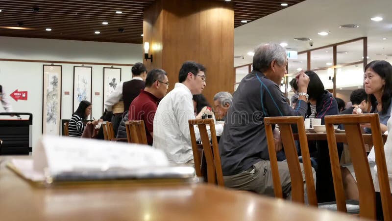 El movimiento de la gente goza de las comidas dentro del restaurante chino