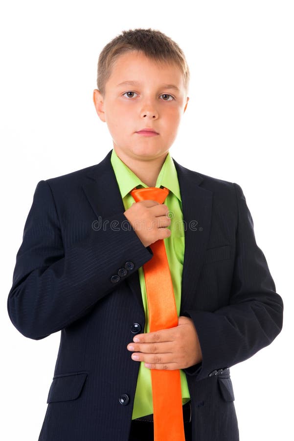 El muchacho lindo del adolescente en el traje de negocios trasero que corregía el lazo sobre blanco aisló el fondo, medio cuerpo, foto de archivo El muchacho lindo del adolescente en el traje de negocios trasero que corregía el lazo sobre blanco aisló el fondo, medio cuerpo, foto de archivo