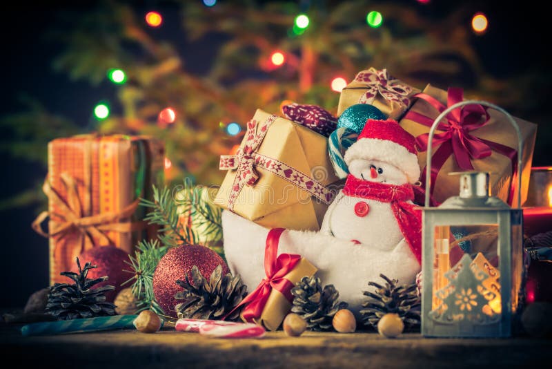 El muñeco de nieve de la tarjeta de Navidad adorna el fondo de las luces del árbol de los regalos fotos de archivo El muñeco de nieve de la tarjeta de Navidad adorna el fondo de las luces del árbol de los regalos fotos de archivo