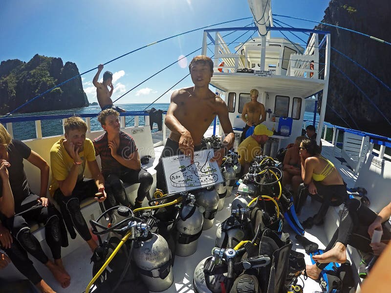 Asian dive instructor giving a dive briefing to a group of tourists royalty free stock images Asian dive instructor giving a dive briefing to a group of tourists royalty free stock images