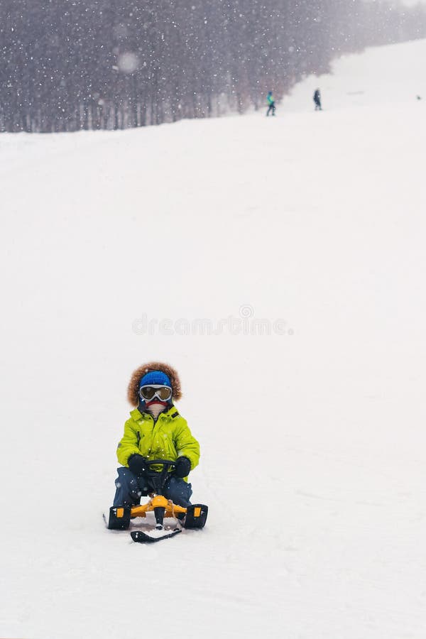 El niño feliz sledding en día de invierno nevoso Niño del niño que monta un trineo Días de fiesta de invierno Niñez feliz Vacacio fotos de archivo El niño feliz sledding en día de invierno nevoso Niño del niño que monta un trineo Días de fiesta de invierno Niñez feliz Vacacio fotos de archivo
