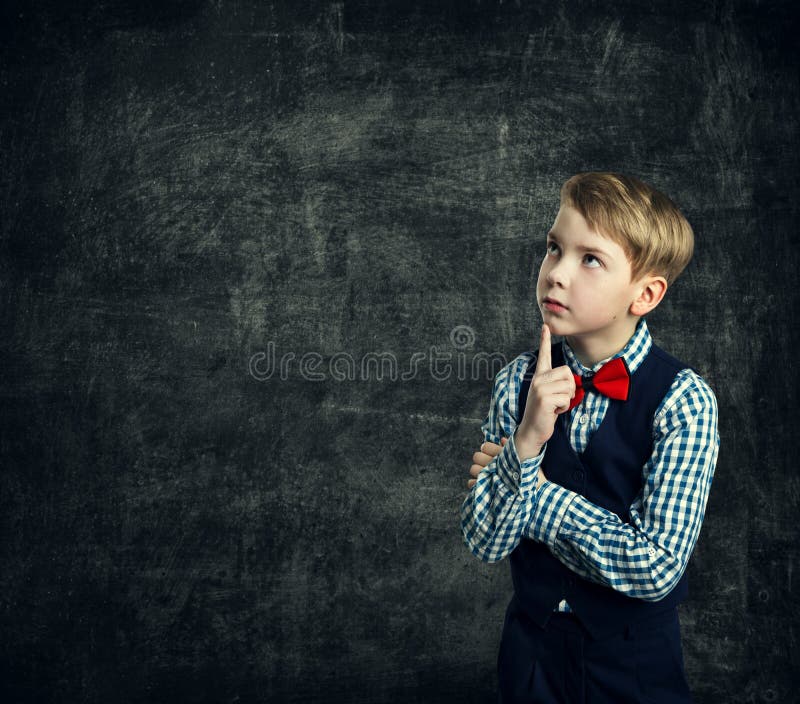 El niño que piensa sobre la pizarra de la escuela, muchacho del niño piensa la educación fotos de archivo