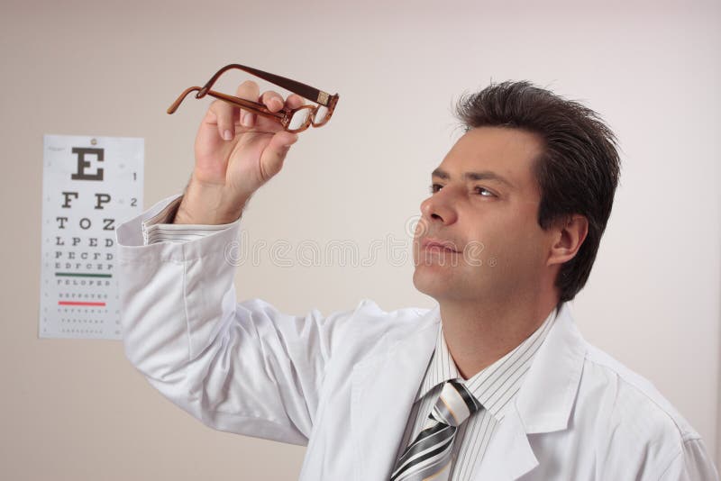 El optómetra revisa los vidrios del ojo fotos de archivo El optómetra revisa los vidrios del ojo fotos de archivo