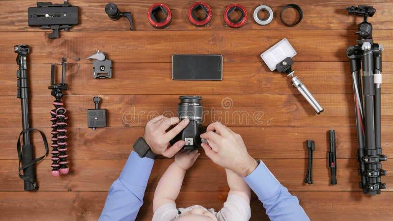 El padre del fotógrafo con un hijo joven comprobó la cámara antes de tirar Opinión de sobremesa de madera Niño que toca a