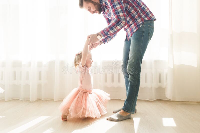 El Padre Enseña Para Bailar a Su Pequeña Hija Linda Imagen de archivo