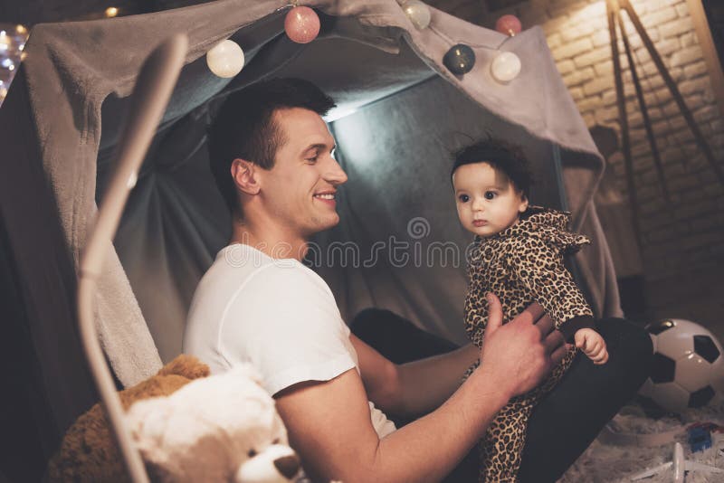 El padre está jugando con la pequeña hija del bebé en la noche en casa imagen de archivo libre de regalías El padre está jugando con la pequeña hija del bebé en la noche en casa imagen de archivo libre de regalías