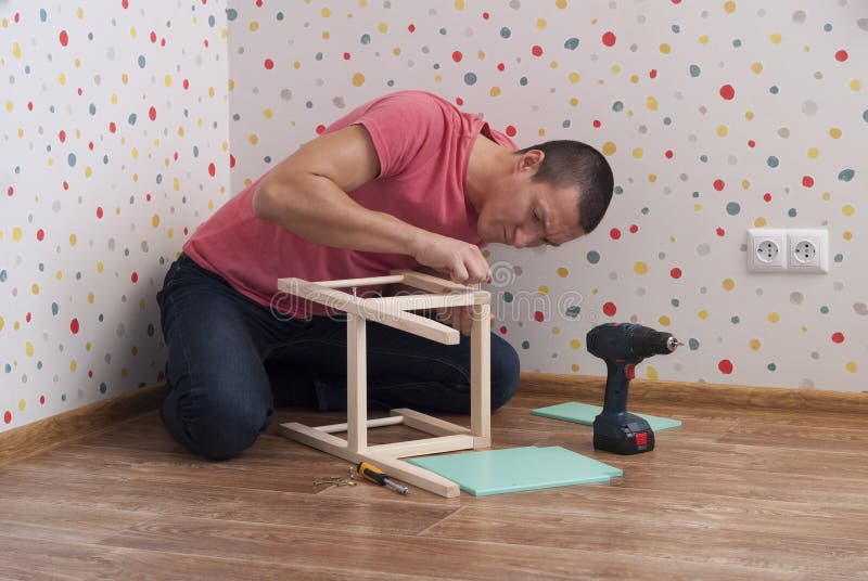 El padre monta una silla para los niños fotografía de archivo El padre monta una silla para los niños fotografía de archivo