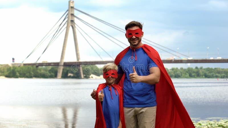 El padre y el hijo en super héroe viste mostrar los pulgares para arriba, la motivación y el trabajo en equipo fotos de archivo libres de regalías El padre y el hijo en super héroe viste mostrar los pulgares para arriba, la motivación y el trabajo en equipo fotos de archivo libres de regalías